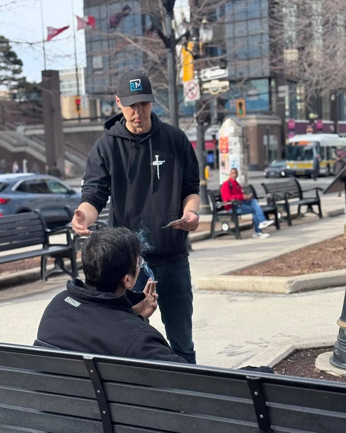 Daniel Ziedins having a conversation with a man on a downtown Hamilton bench