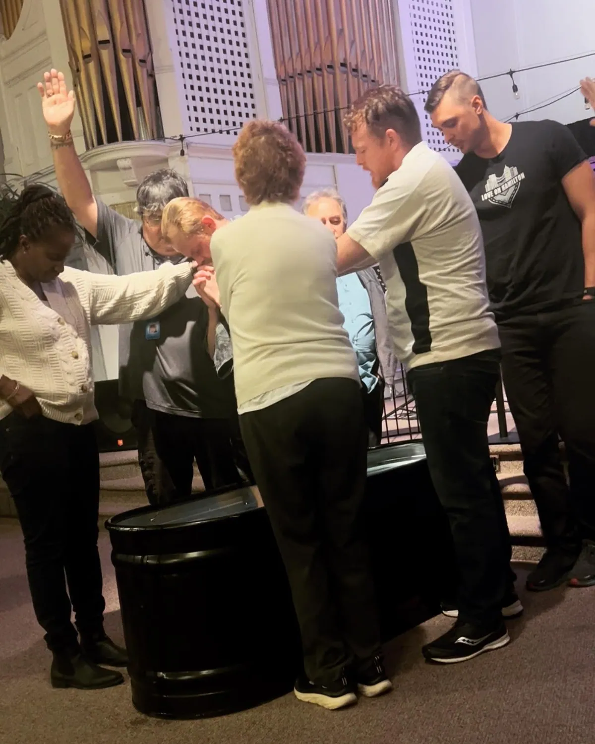 Christians praying with someone during community outreach