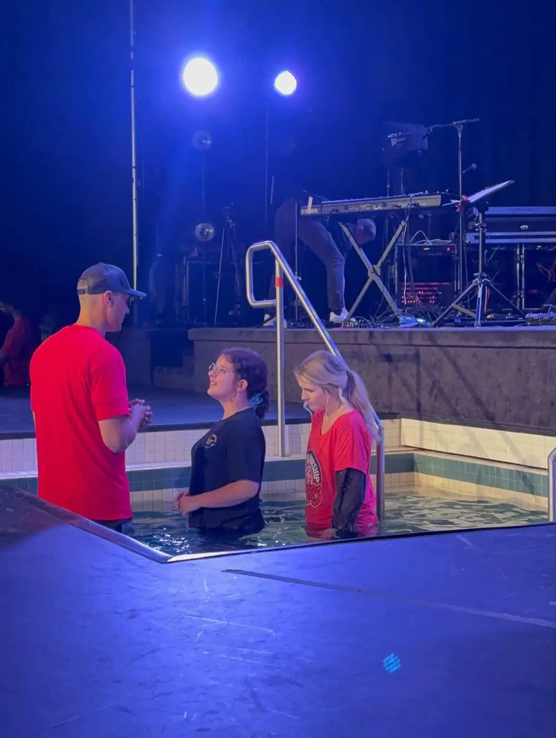 Two women being baptised in a tank in front of the stage at Jesus Festival in Gage Park, Hamilton