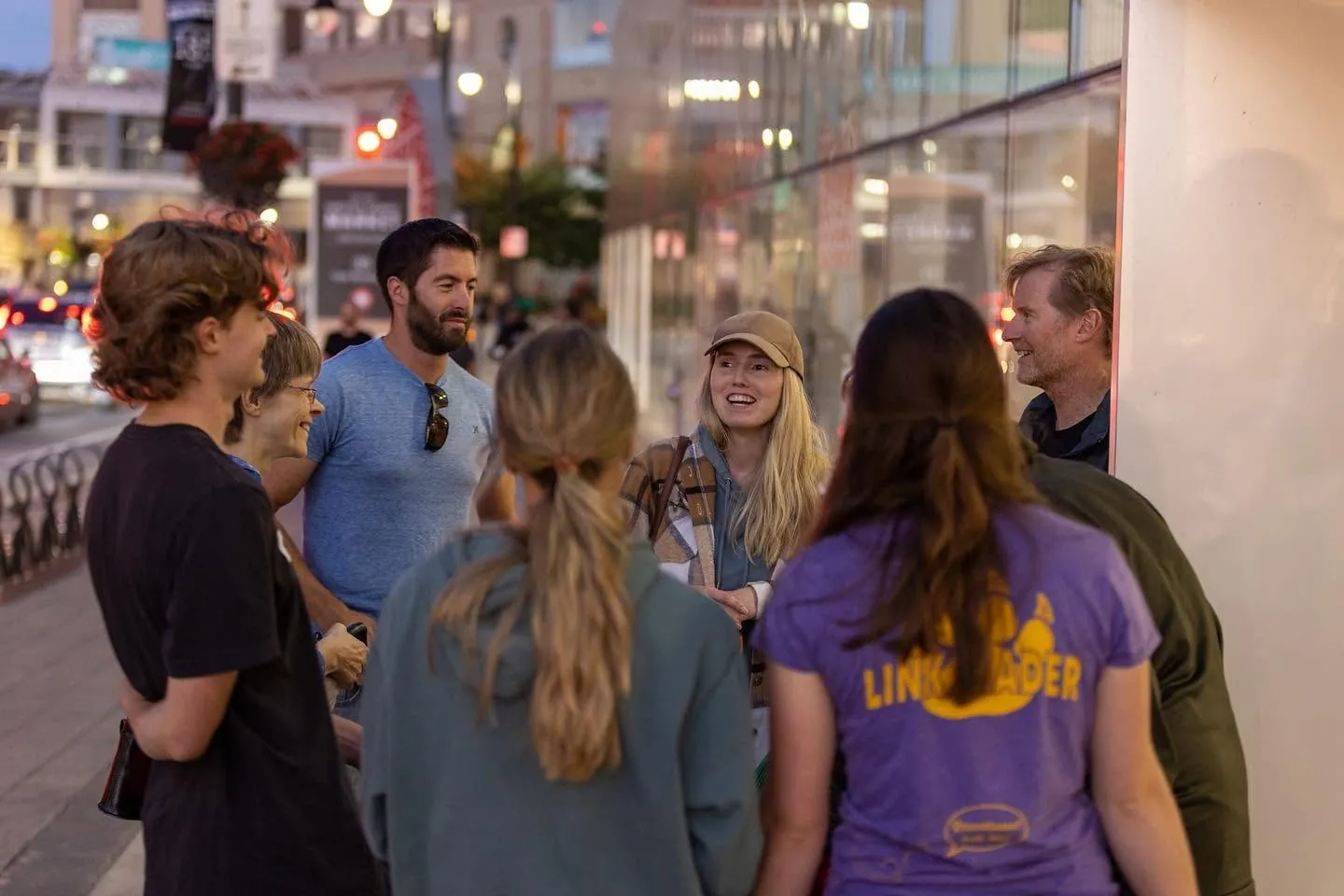 A group of people talking together downtown at dusk