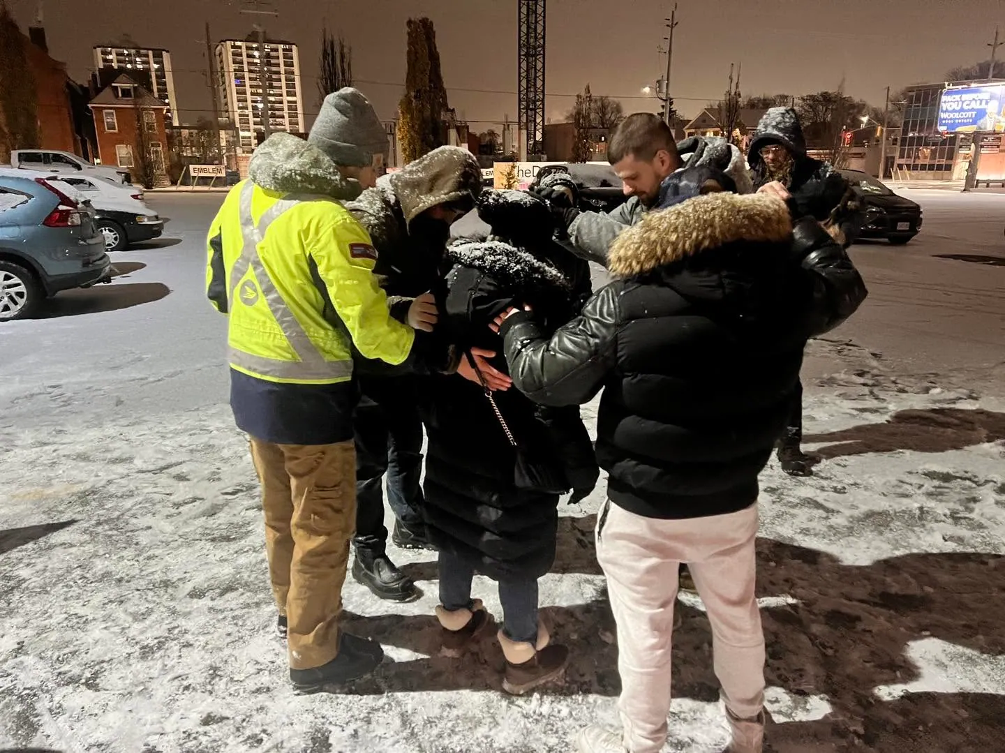 An outreach team praying together on a winter street